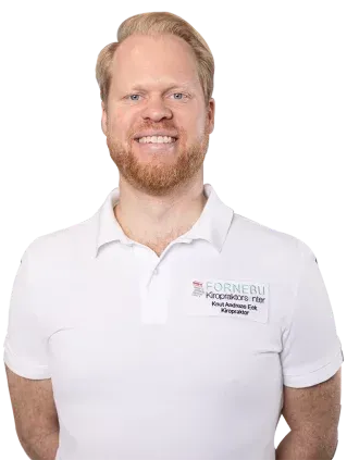 Smilende mann med rødt hår og skjegg, iført en hvit poloskjorte med logo.